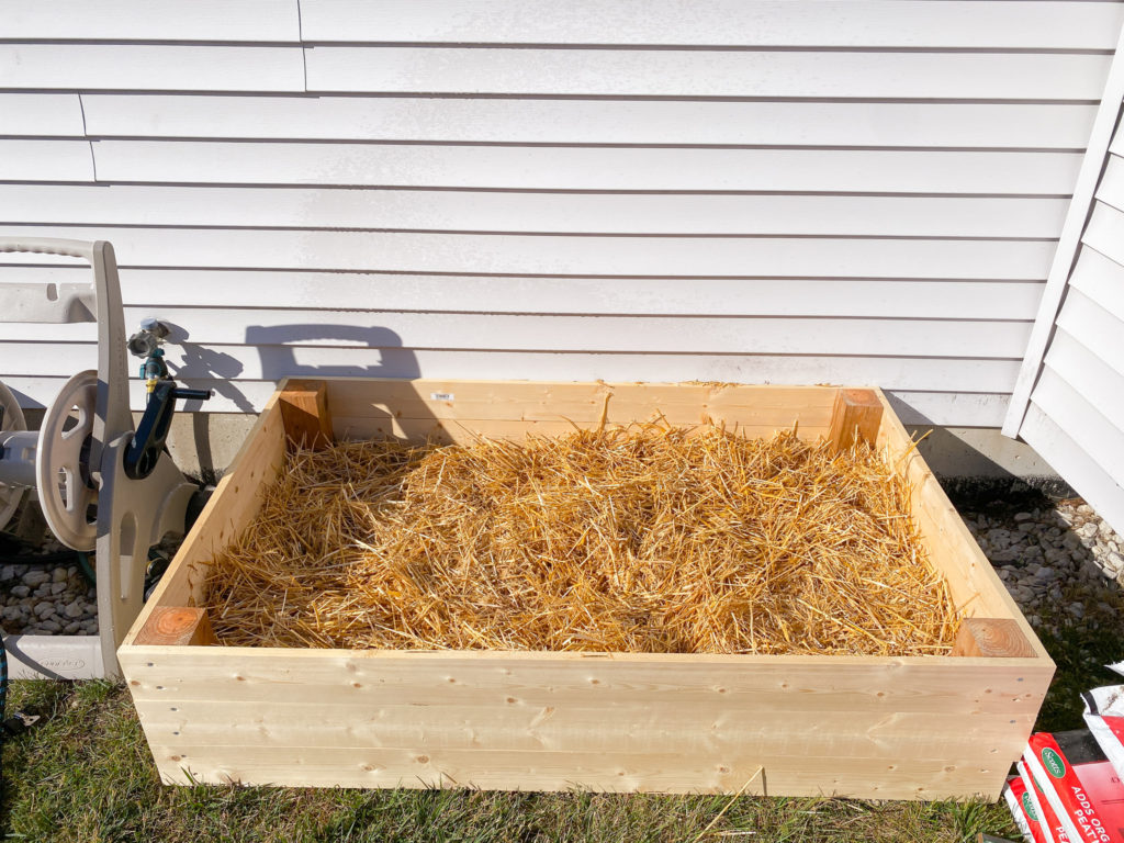 layering garden bed with hay